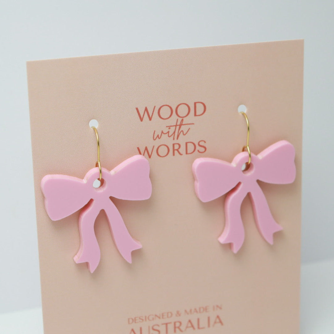 Pink bow earrings on a 'Wood with Words' card