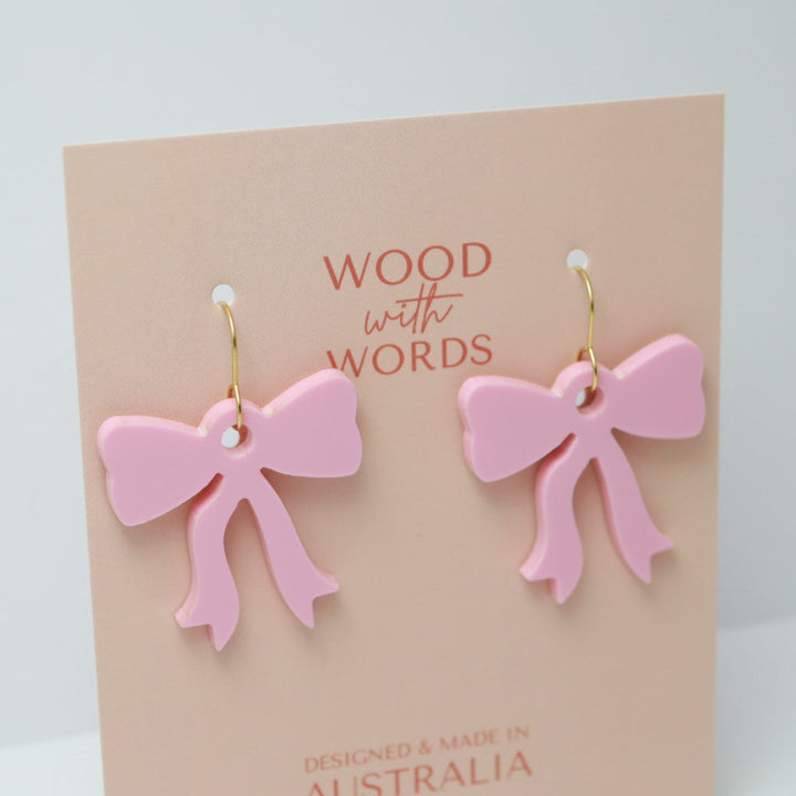 Pink bow earrings on a 'Wood with Words' card